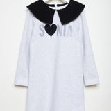light grey cotton dress with large black velvet collar and glittery silver logo on the front